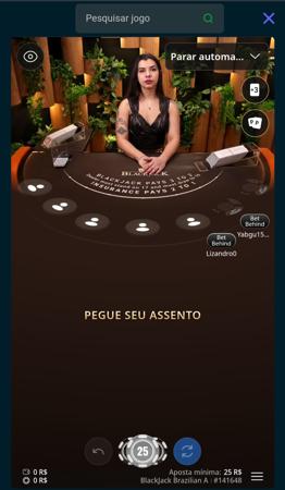 Mesa de Blackjack no cassino VBET, com crupiê ao vivo convidando jogadores a ocuparem seus assentos